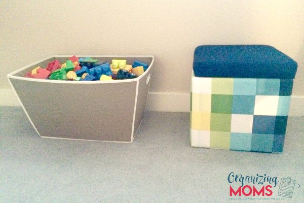 Bin filled with toys, toy storage stool on floor