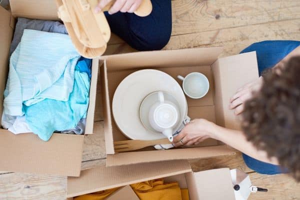 two people unpacking kitchen boxes alongside each other