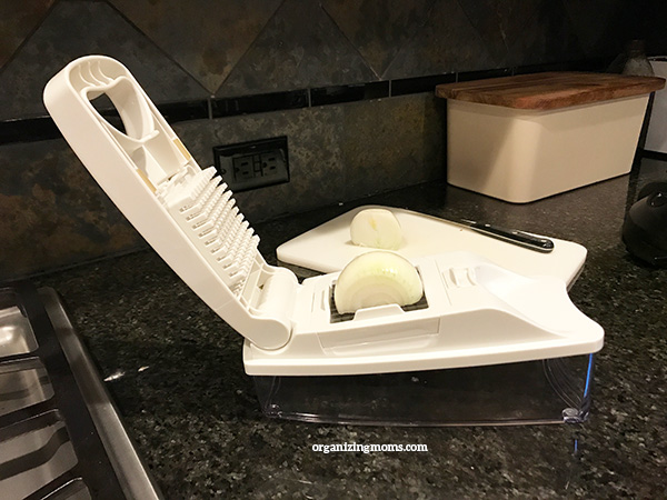 Onion in vegetable chopper on granite countertop.