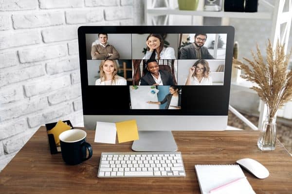 computer screen on desk shows zoom call in progress