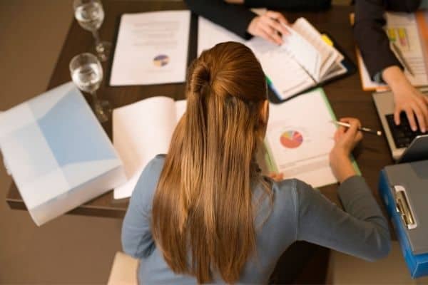 woman looking at papers on her desk