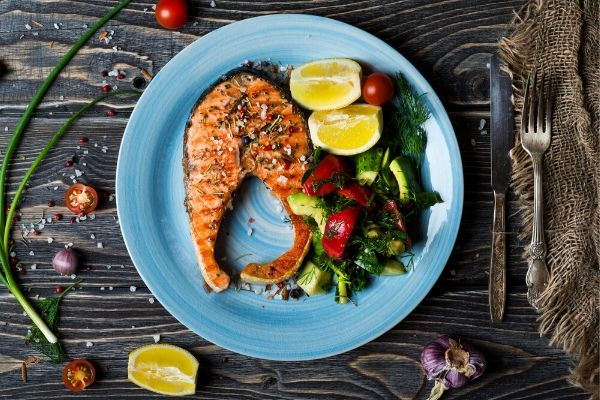 A blue plate of food on a table, with Salmon