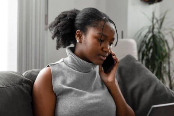 woman sitting on sofa talking on phone